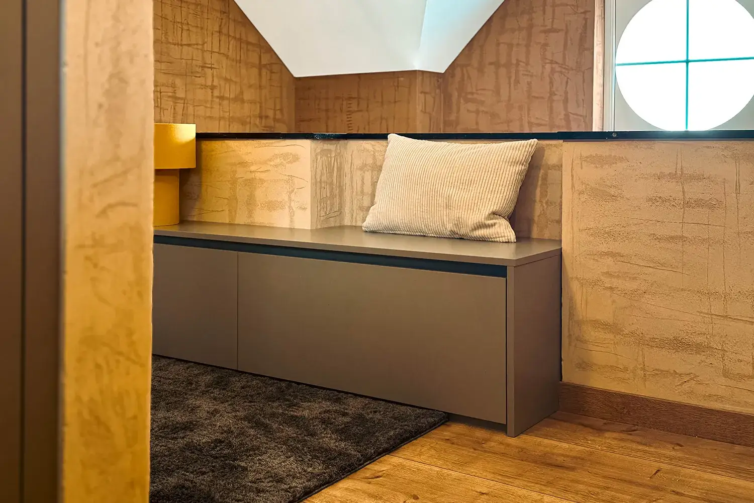 Banquette sur mesure avec rangements intégrés dans un intérieur contemporain aux tons chaleureux