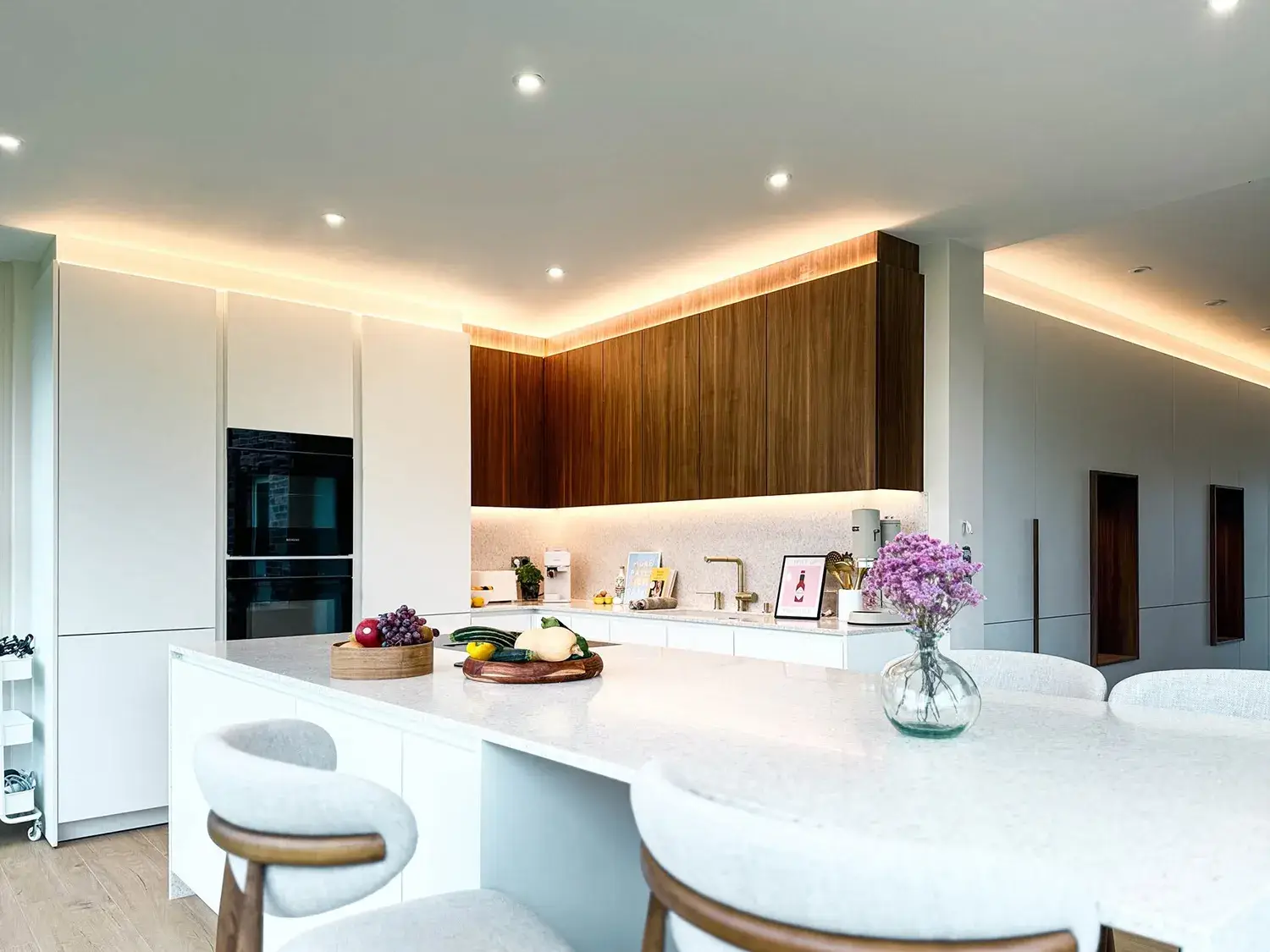 Cuisine sur mesure moderne avec grand îlot central, rangements intégrés et espace repas ouvert sur le séjour