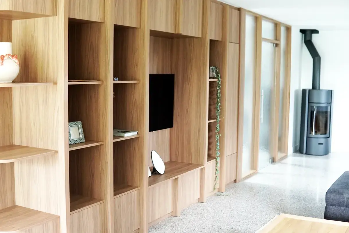 Meuble TV sur mesure en bois avec bibliothèque intégrée, rangements et niches ouvertes dans un salon contemporain